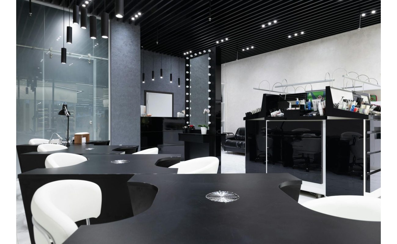Sleek and elegant nail salon interior featuring modern black and white decor, stylish furniture, and bright lighting.