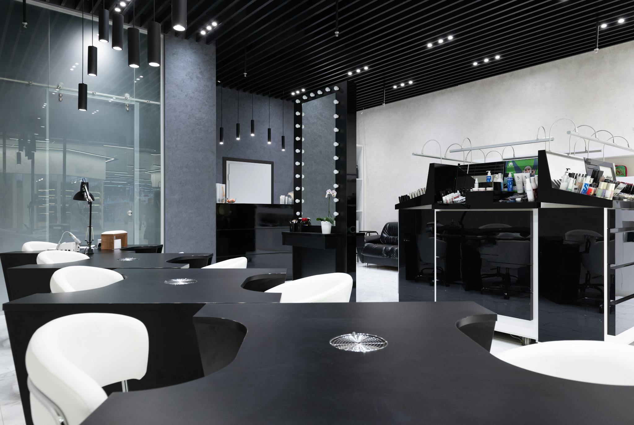 Sleek and elegant nail salon interior featuring modern black and white decor, stylish furniture, and bright lighting.