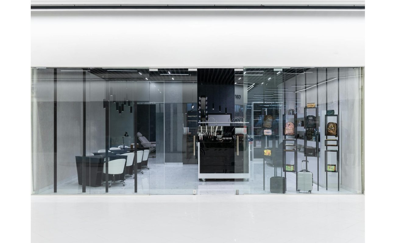 Sleek interior of a modern store with glass facade, stylish furniture, and display items.